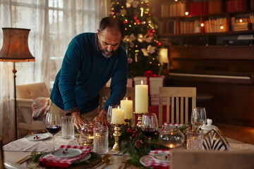 Fototapeta na wymiar Middle age man serving festive holiday table