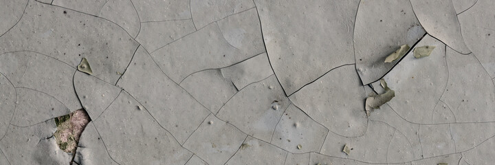 Obraz premium Peeling paint on the wall. Panorama of a concrete wall with old cracked flaking paint. Weathered rough painted surface with patterns of cracks and peeling. Grunge texture for wide panoramic background