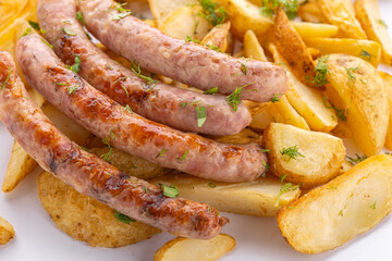Fried sausages and fries on a white background, takeaway food, close-up.