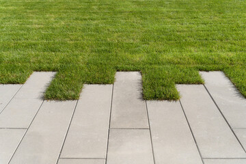 Lawn grass and sidewalk path on the walking area in the garden or park. Landscaping of the lawn and...