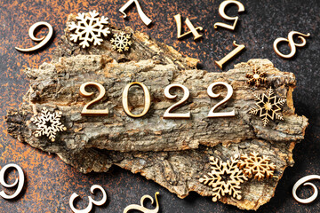 Happy new year 2022. Wooden Christmas or new year decorations on a wooden brown background. ECO...