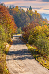 Fototapeta na wymiar old mountain road in morning light. trees in colorful foliage along the serpentine. explore countryside concept