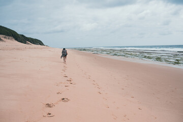 Rear view of woman seen walking alone on beach