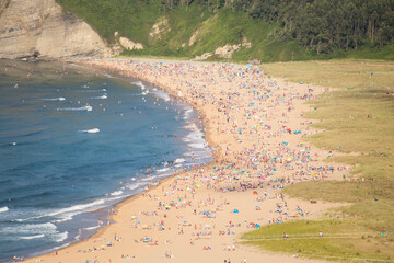 Fototapeta na wymiar aerial view of a crowded beach. sunny day. people enjoying a holiday or a weekend.