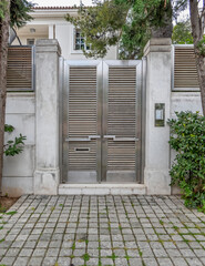 contemporary house front entrance stainless steel door by the sidewalk, Athens Greece