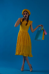 smiling woman in a yellow hat Shopaholic fashion style blue background
