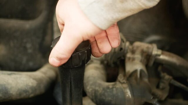 Hand of a mechanic repairman adding or pouring oil to the old car engine. diesel not ecology friendly engine