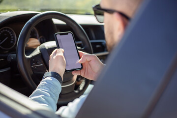 man using smartphone while driving car.