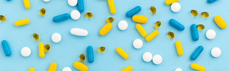 Colorful medical pills on blue background. Top view flat lay