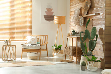 Stylish living room interior with comfortable wooden armchair and beautiful houseplants