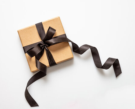Black Friday sale concept, Gift box with black ribbon isolated on white background, top view.