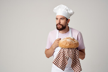 a man in a cook's uniform with bread in his hands baking cooking work