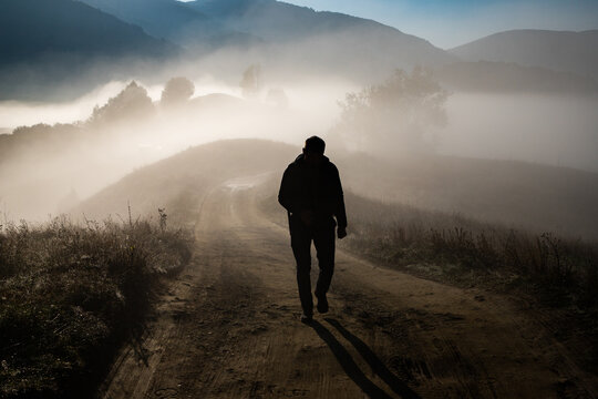 man walking in a foggy autumn landscape