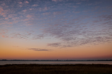 Sunrise wide sky over lagoon of Barth, with silhouette of church and town, Mecklenburg-Western Pomerania, Germany