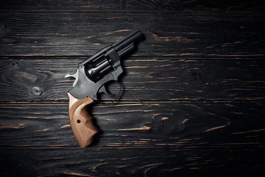 Revolver pistol on dark wooden background