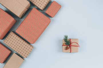Winter holiday present wrapped in recycled paper decorated with spruce twigs and acorns. Christmas gift, eco friendly packaging, flat lay top view.