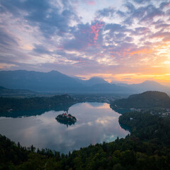 Beautiful view of lake Bled in Slovenia. Mountain scenery with popular tourist destination under sunlit sky during the sunrise.
