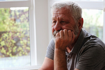 Senior retired man sitting at home alone while quarantine