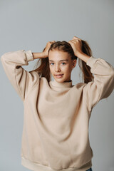 Confident pretty teenage girl holding her hair in pony tails.