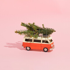 A Christmas arrangement made of red vans and green pine branches on a pastel pink background. Minimal New Year concept. Christmas tree and Christmas time inspiration.