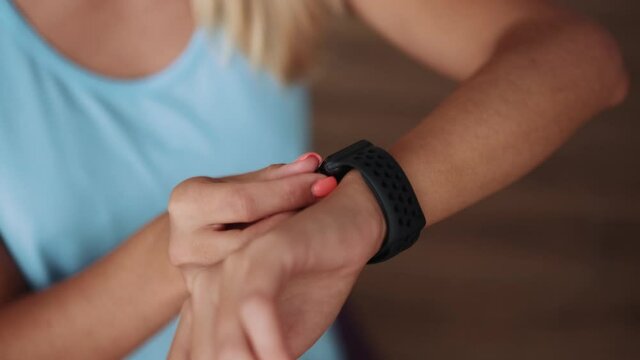 Close-up view of woman's hands customizing smart watch at home