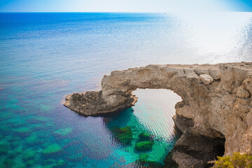 Beautiful picturesque cliffs of Ayia Napa in Cyprus. Arch Bridge of lovers. On the Mediterranean coast, background with a beautiful rock texture as a concept for travel and tourist excursions.