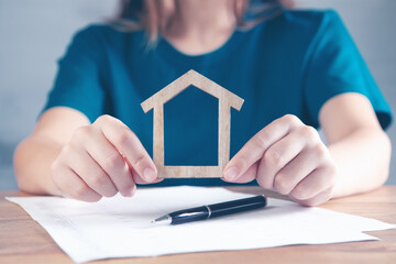 woman holding house by papers