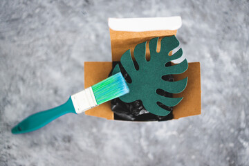 greenwashing and companies pretending to be sustainable, paper leaf with green brush painting on it...