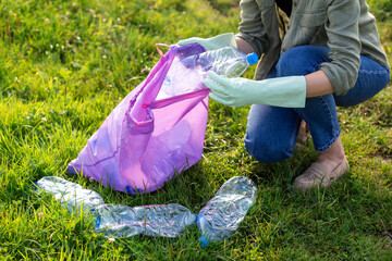 Banner volunteer hands picks up a plastic trash. Woman collect plastic bottles on the grass in the park. Global problem of environmental pollution. Eco friendly. Go green