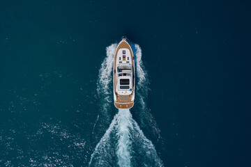 Yacht movement on blue water top view. Luxury yacht on the water aerial view. White yacht fast...
