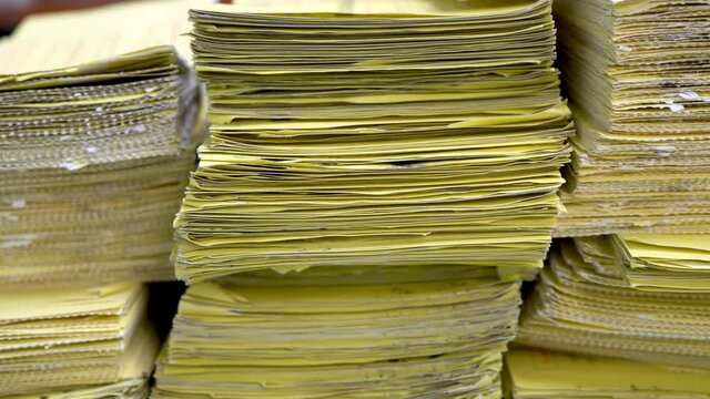 Stack of yellow documents on desktop in office.