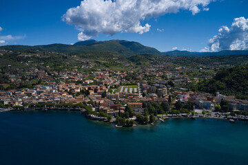 Fototapeta na wymiar Aerial view of the city of Garda, Lake Garda, Italy. Panorama on corno. Vista lago on the coastline. Top view of the Museum of Lake Garda on the coastline.