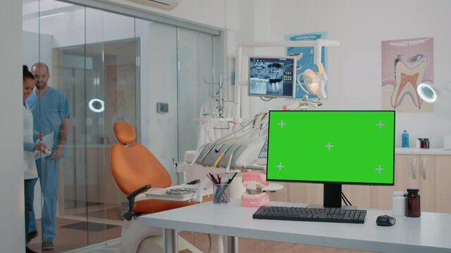 Horizontal green screen on computer in dentist office while specialists using equipment for dental care. Monitor with chroma key and isolated mockup template in office for teethcare.