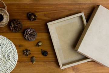 Craft brown box with dry nature flower on wooden table. 