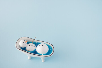 Snowman  having a bath.  Minimal New Year and Christmas concept. Blue creative background.