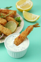 Сoncept of tasty food with deep-fried shrimp on mint background