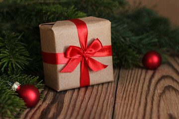 Christmas gift and fir branches on a wooden background