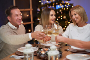 Friends celebrating christmas party holding wine