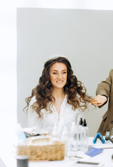 Stylist preparing bride before the wedding in a morning