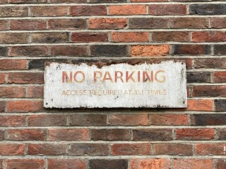 old no parking sign on a wall