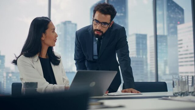 Modern Office: Portrait of Successful Corporate CEO and Top Manager Talk, Use Laptop Computer. Businesspeople Discuss Investment in Digital e-Commerce Fintech Startup. Multi-Ethnic Working Environment