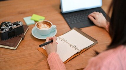 Close-up of a female secretary planning her boss's schedule meeting on her planner book
