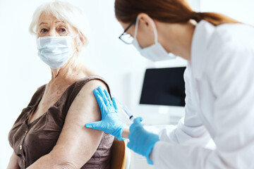 elderly woman with a doctor syringe with vaccine immunity protection