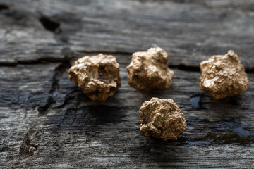 Profit, trade and exchange. Gold nuggets spilling out from a old wood, placed on a old wooden table.Shallow depth of field.selective focus.