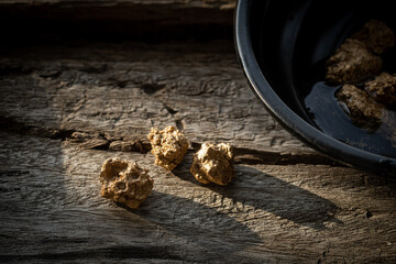 Profit, trade and exchange. Gold nuggets spilling out from a old wood, placed on a old wooden...