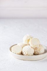 Fototapeta na wymiar Sweet coconut truffles on a light background. Sugar, gluten and lactose free, vegan.