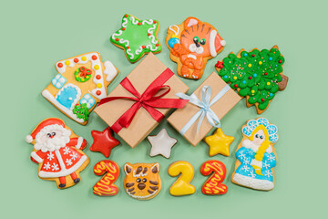 Pattern of gingerbread colorful cookies in different shapes on the green surface. Flat lay. Merry Christmas, New Year, winter concept.
