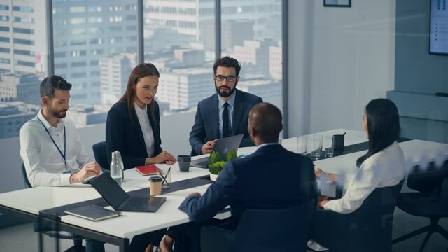 Office Conference Room Meeting: Diverse Team of Top Managers Talk, Use Tablet, Celebrate and Applaud Successful Solutions. Caucasian Businesswoman Presenting Investment Strategy to Investors
