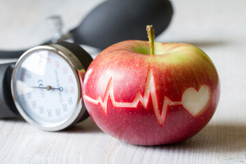 Heartbeat line on red apple and sphygmomanometer, healthy heart diet concept