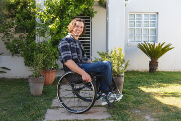 Portrait of caucasian disabled man sitting on wheelchair smiling in the garden